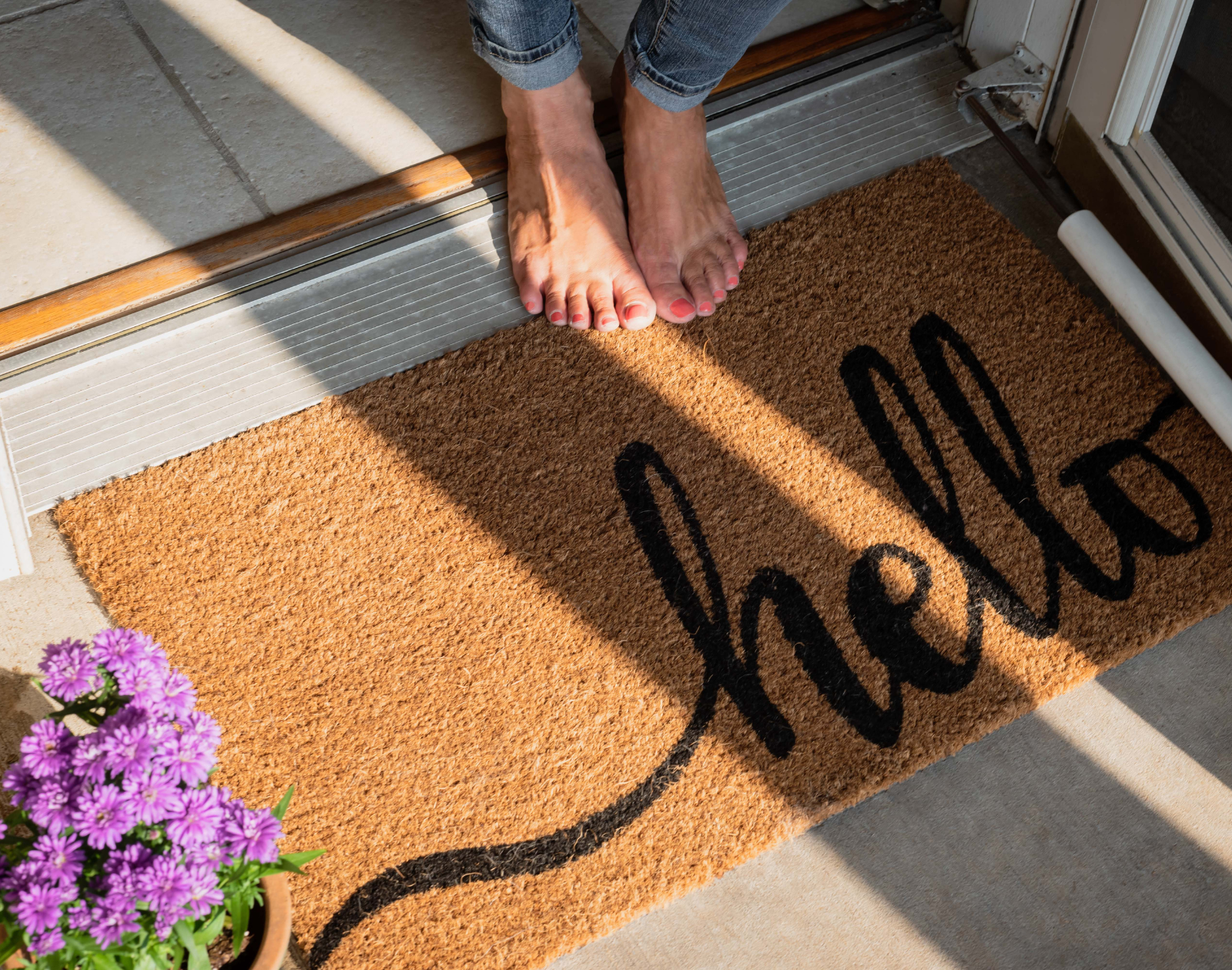 a photo of homeowner's feet with a hello rag welcoming a guest.