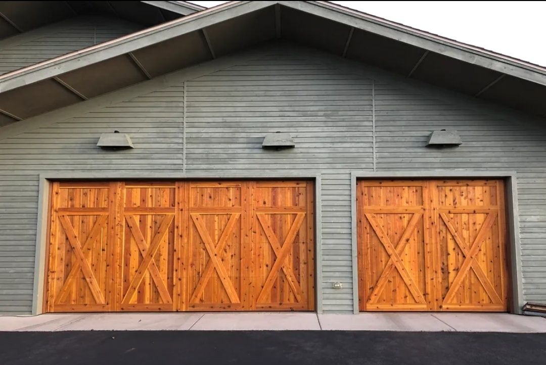 Gray garage with two orange wooden doors under a peaked roof