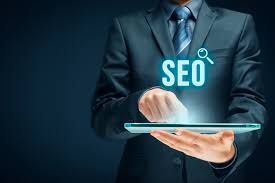 A man in a suit is holding a tablet with the word seo coming out of it.