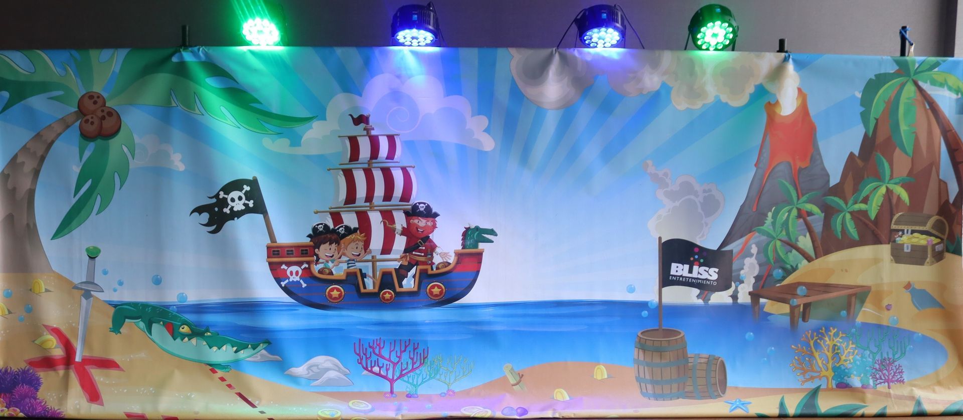 Un barco pirata está flotando en lo alto de una playa al lado de un volcán.