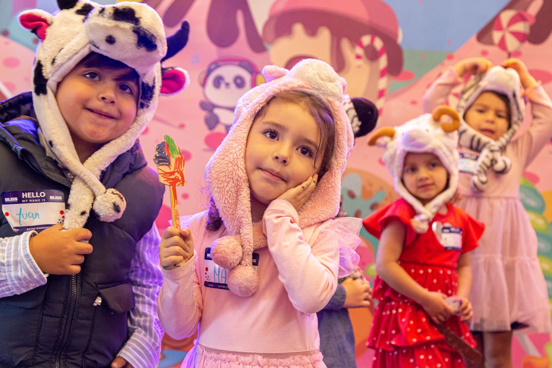 Un grupo de niños que llevan sombreros de animales están parados uno al lado del otro.
