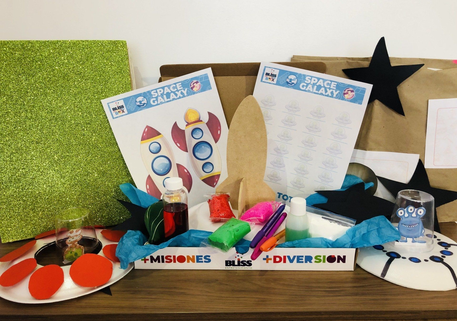 Una caja llena de una variedad de artículos, incluida una pegatina de un cohete.