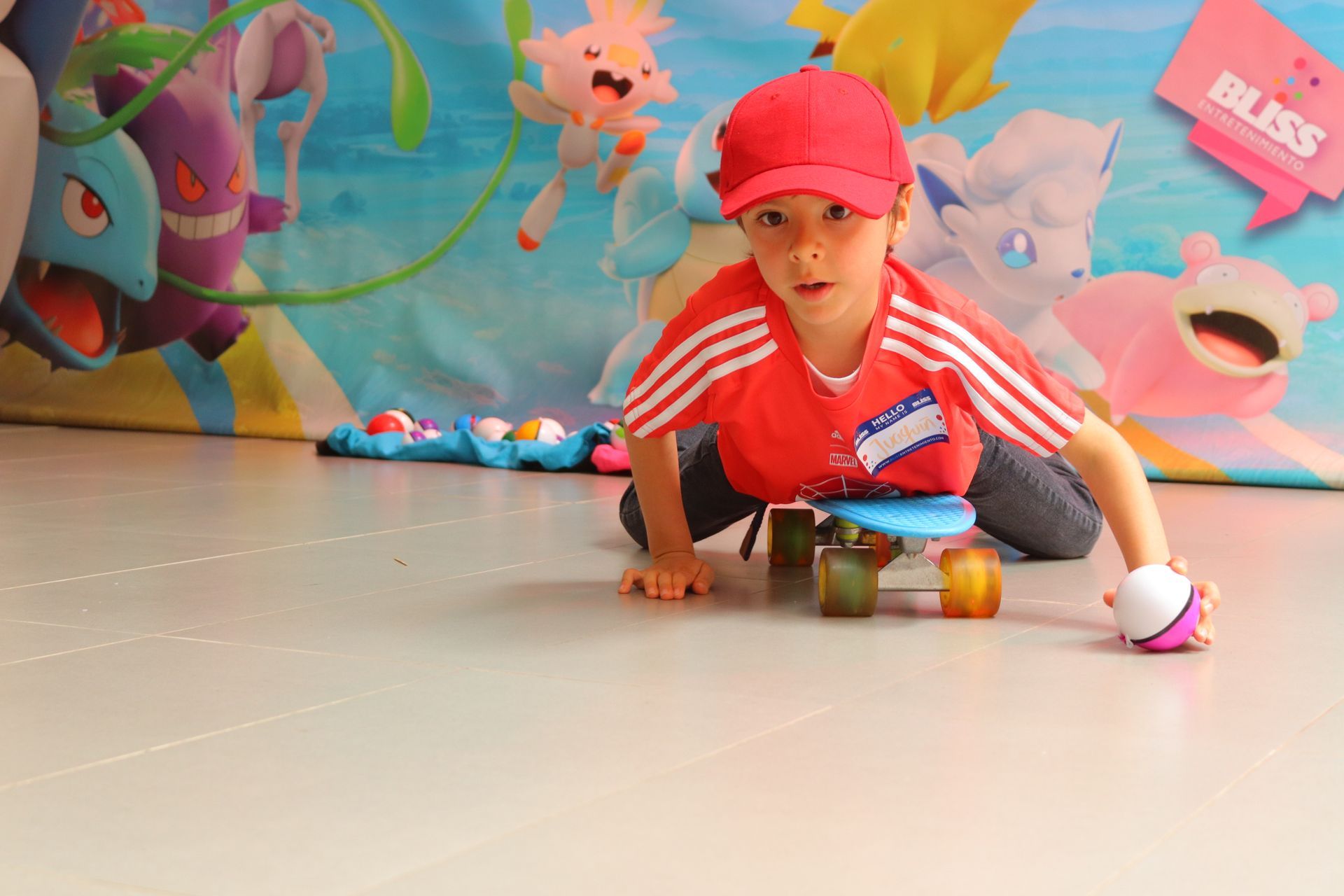 Un niño pequeño que lleva un sombrero rojo está montando una patineta