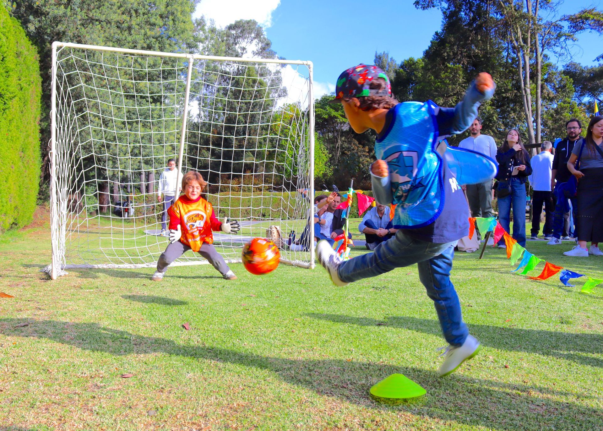 Un niño pequeño está pateando un balón de fútbol en un campo.