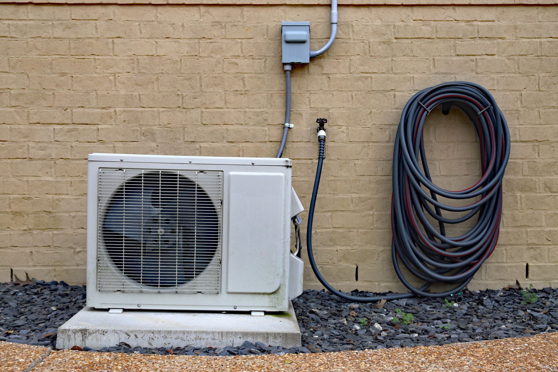 Air Conditioner mini split system next to home with brick wall. Air Conditioner mini split system next to home with brick wall.