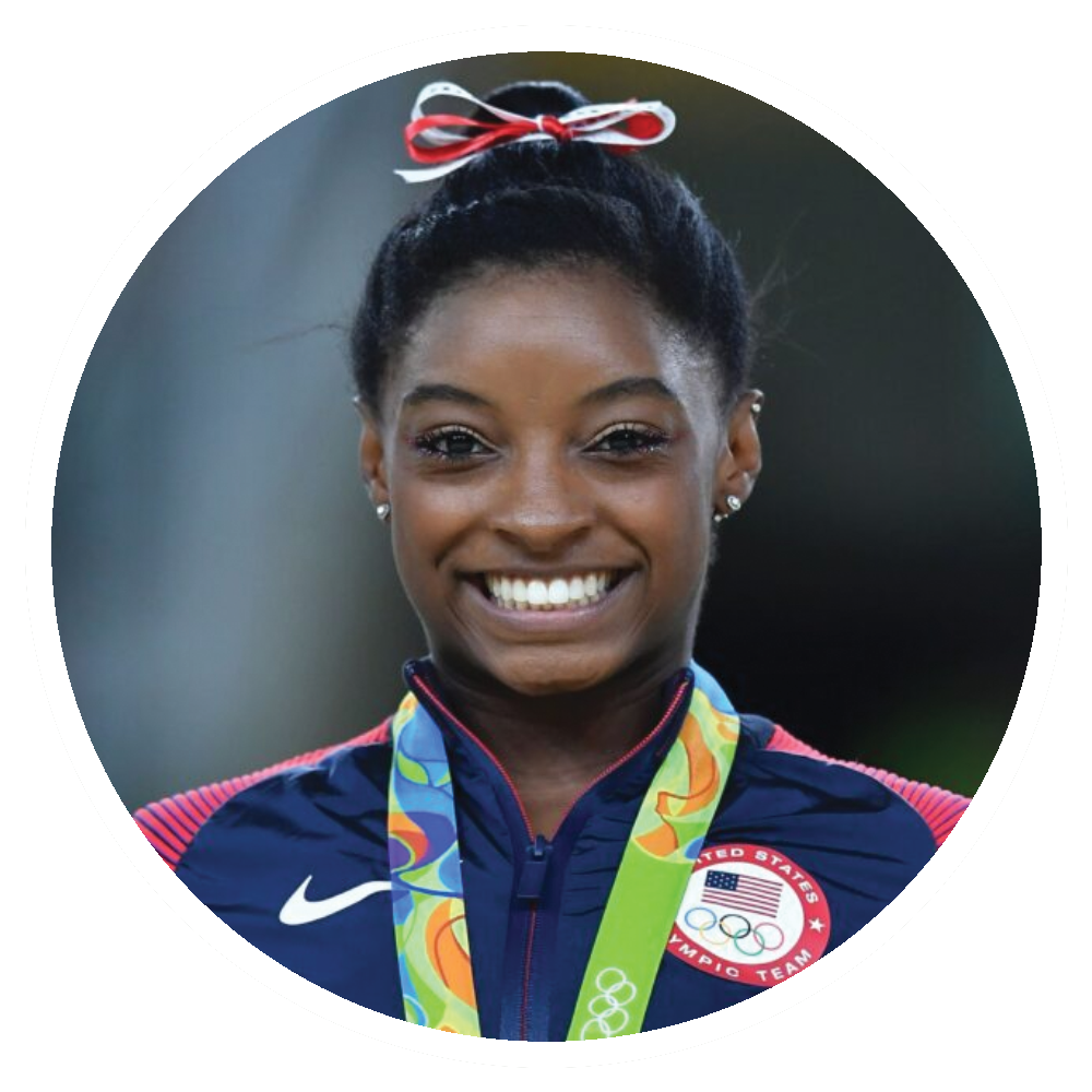 Simone Biles with medal; wearing USA Olympic team jacket and a hair bow.