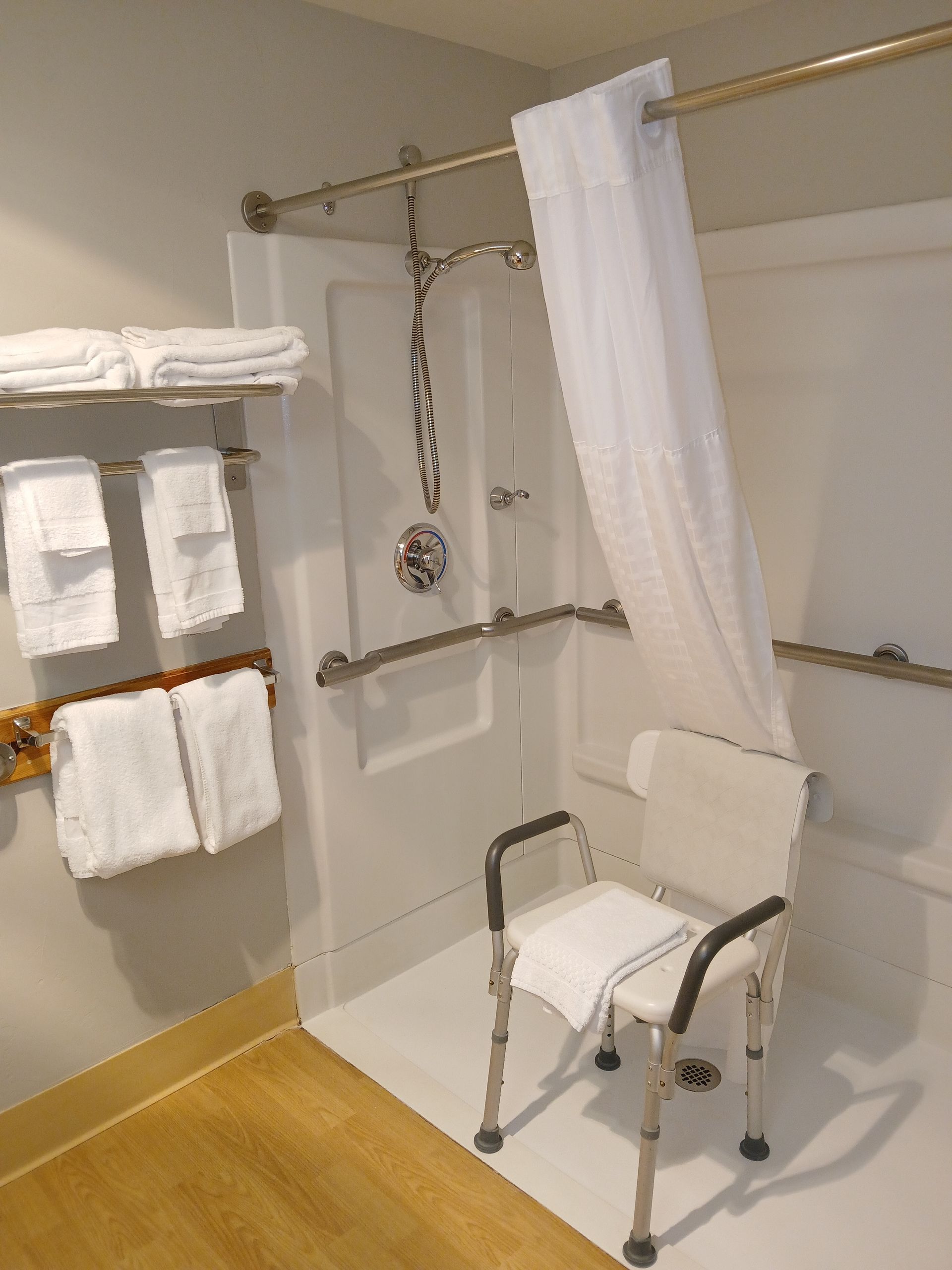 A bathroom with a chair and a shower curtain
