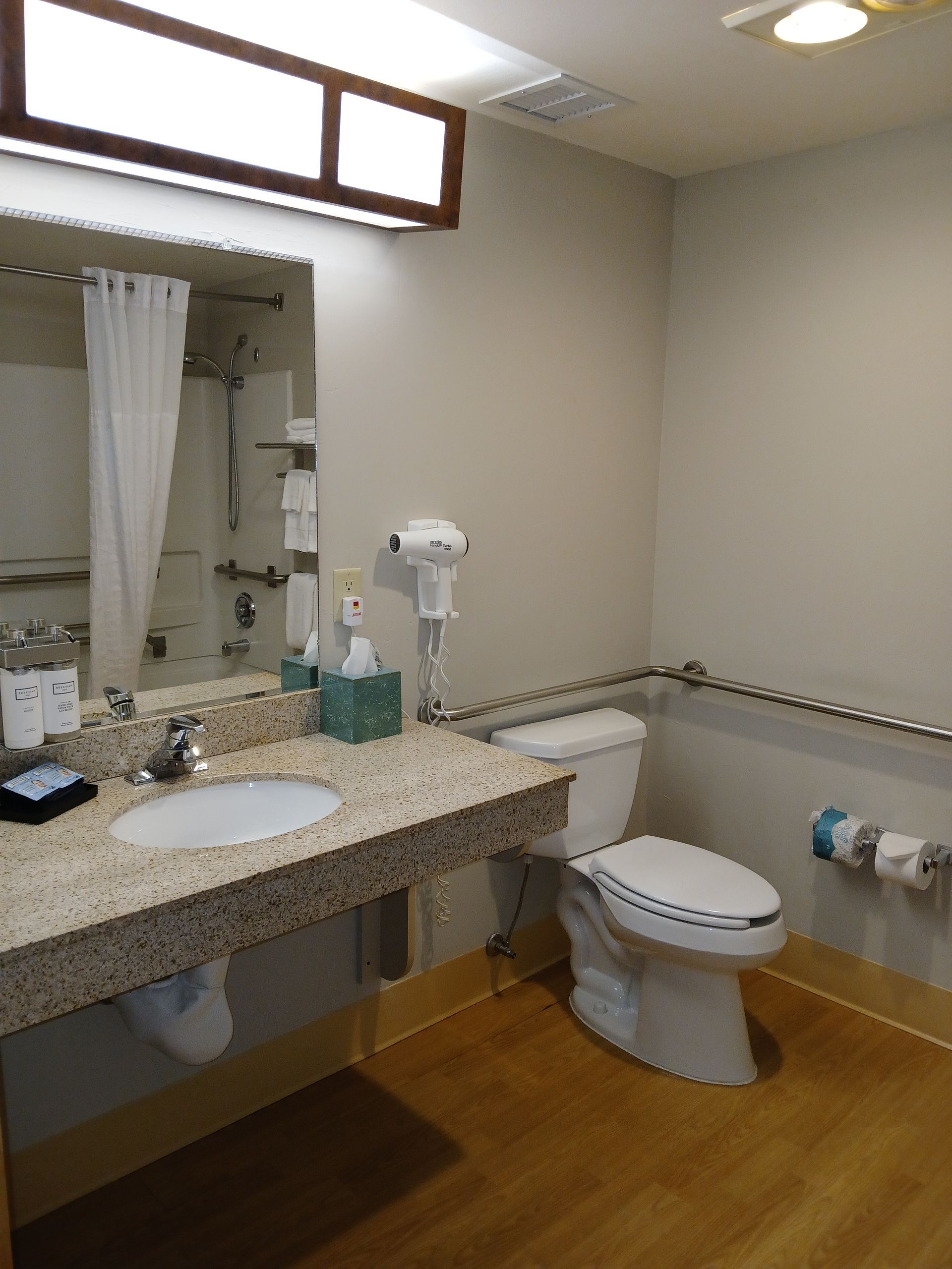 A bathroom with a toilet , sink and mirror