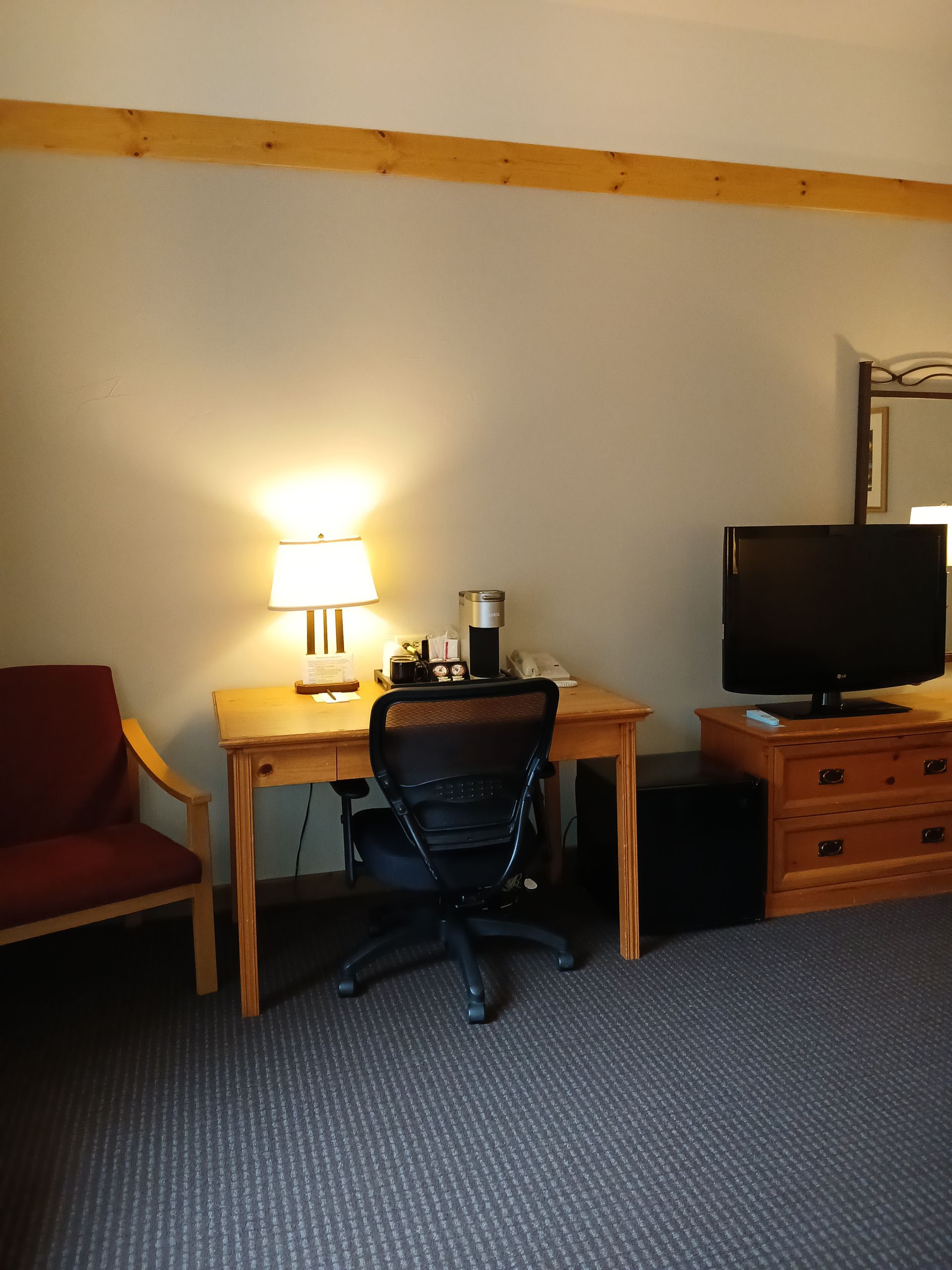 A hotel room with a desk chair and television