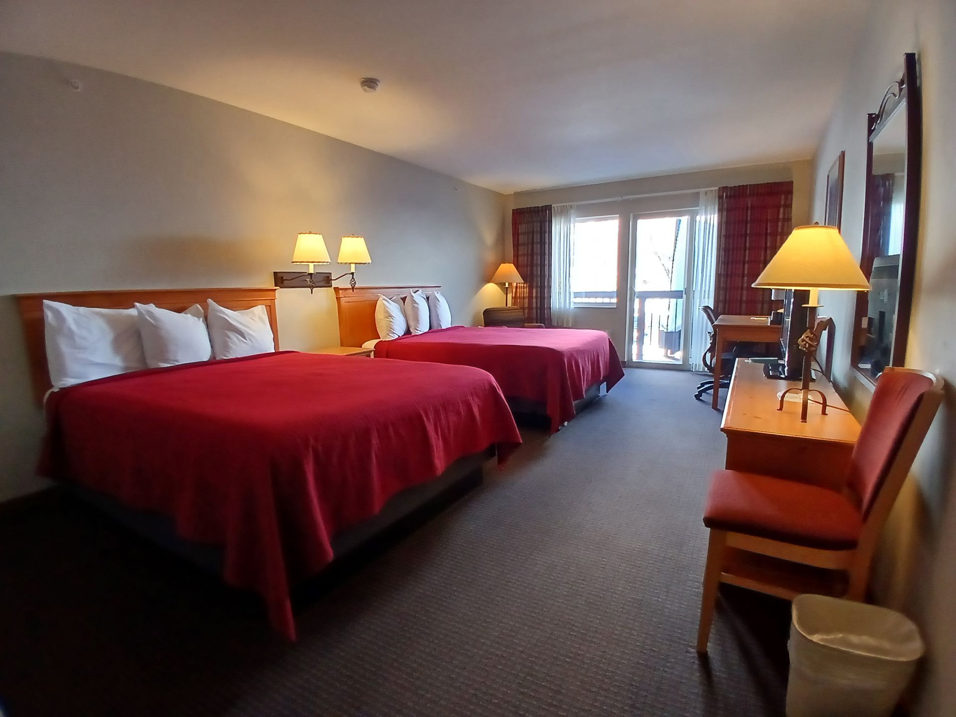 A hotel room with two beds and a desk