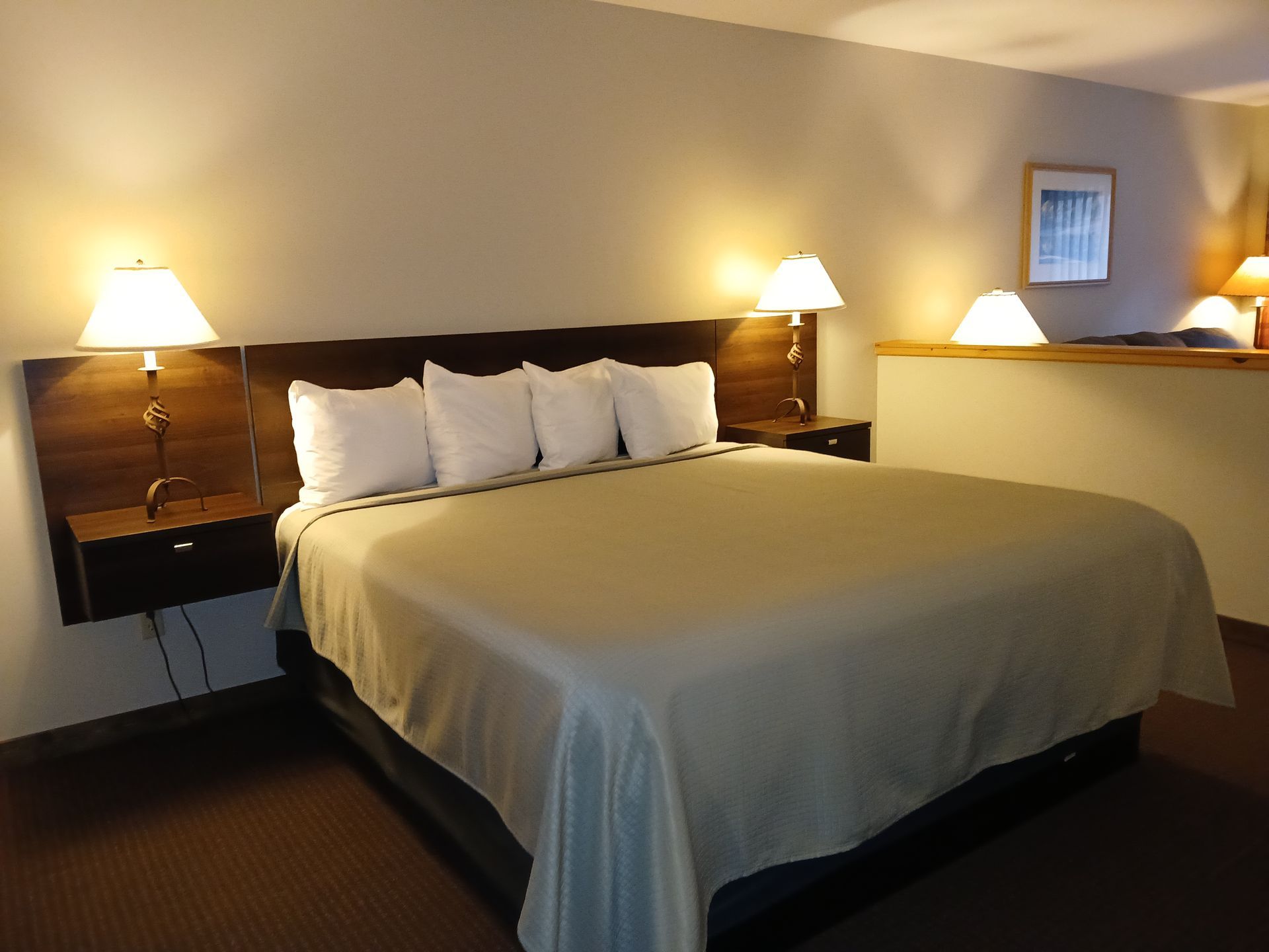 A hotel room with a king size bed and two lamps