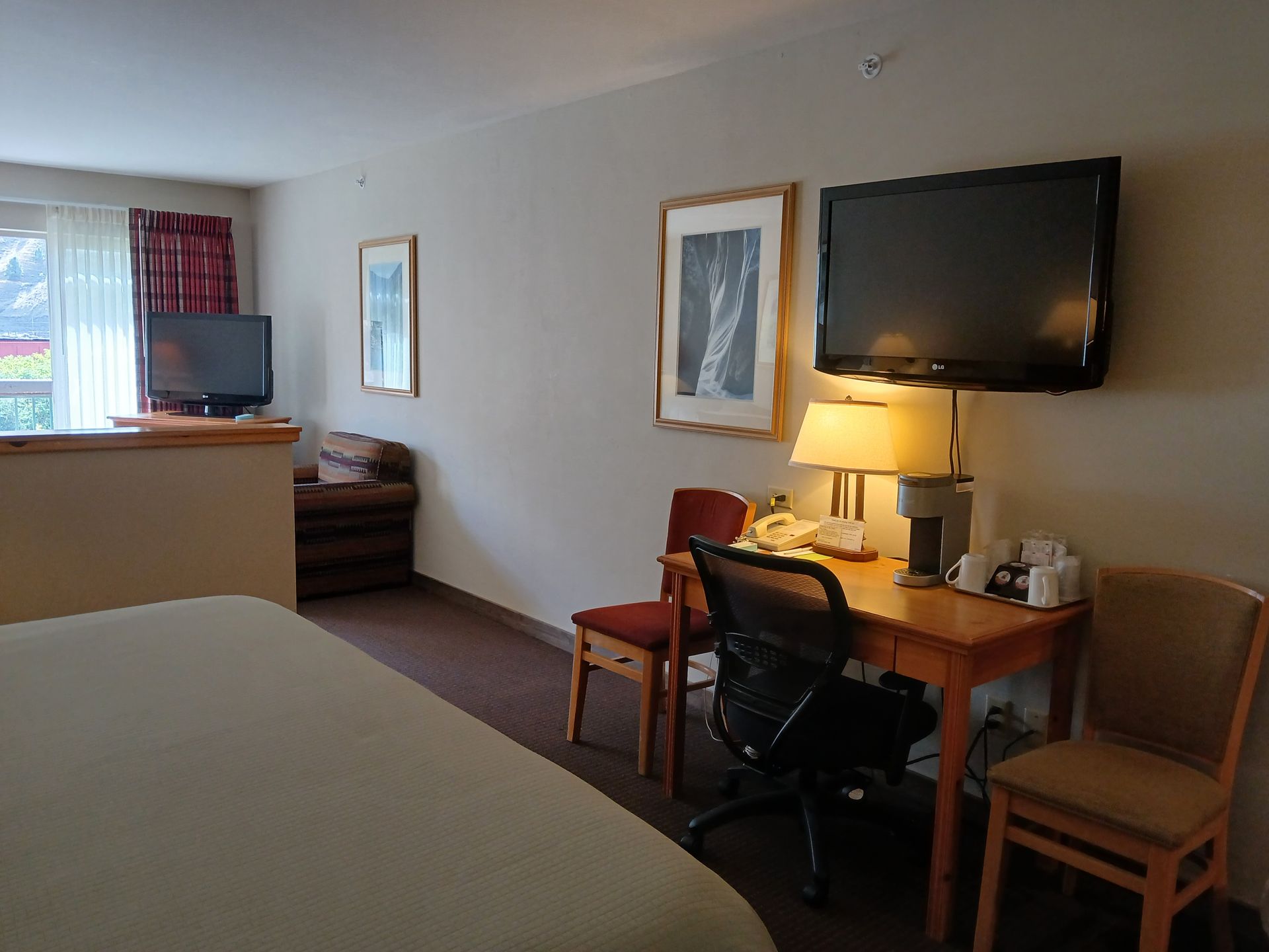 A hotel room with a large flat screen tv on the wall