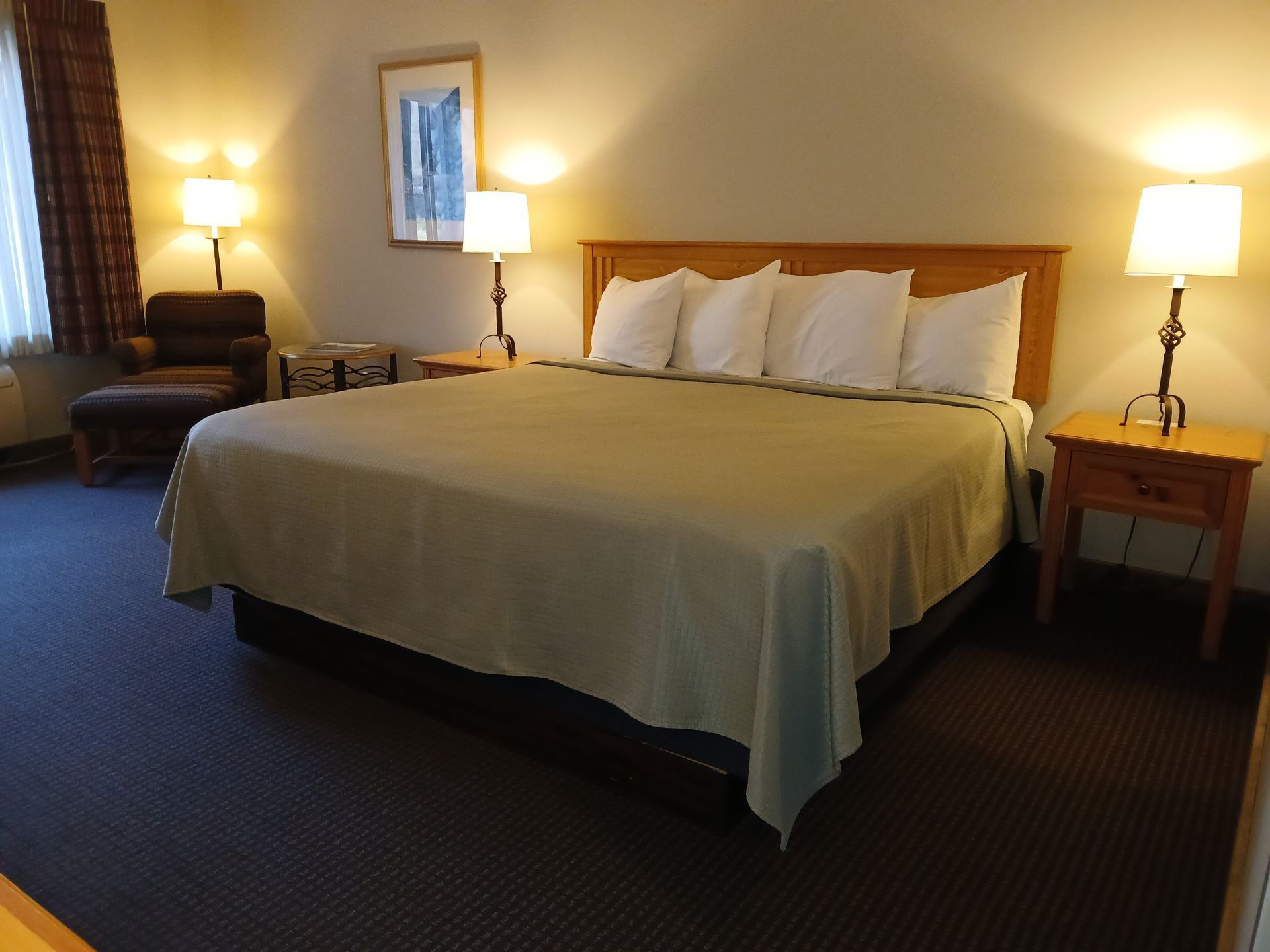 A hotel room with a king size bed and two nightstands