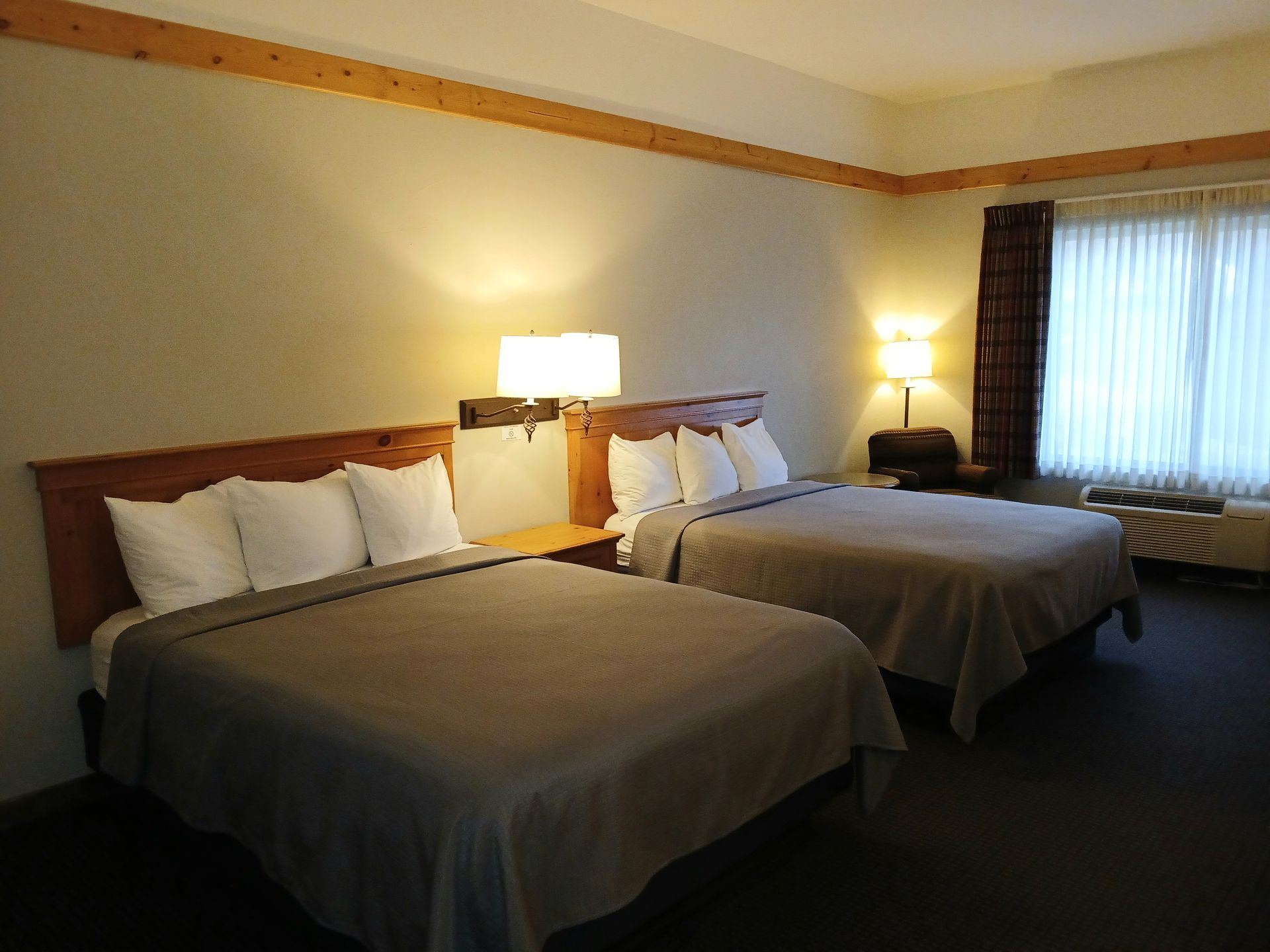 A hotel room with two beds and a desk