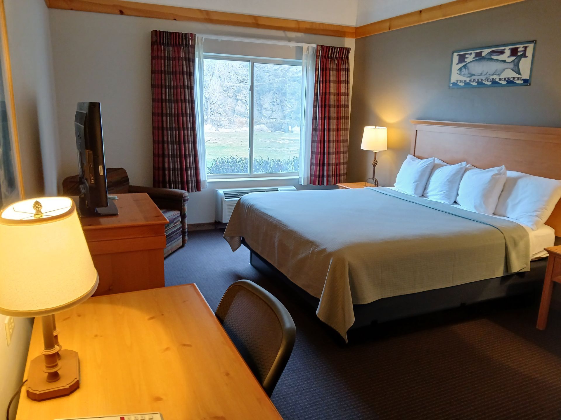 A hotel room with a king size bed and a desk