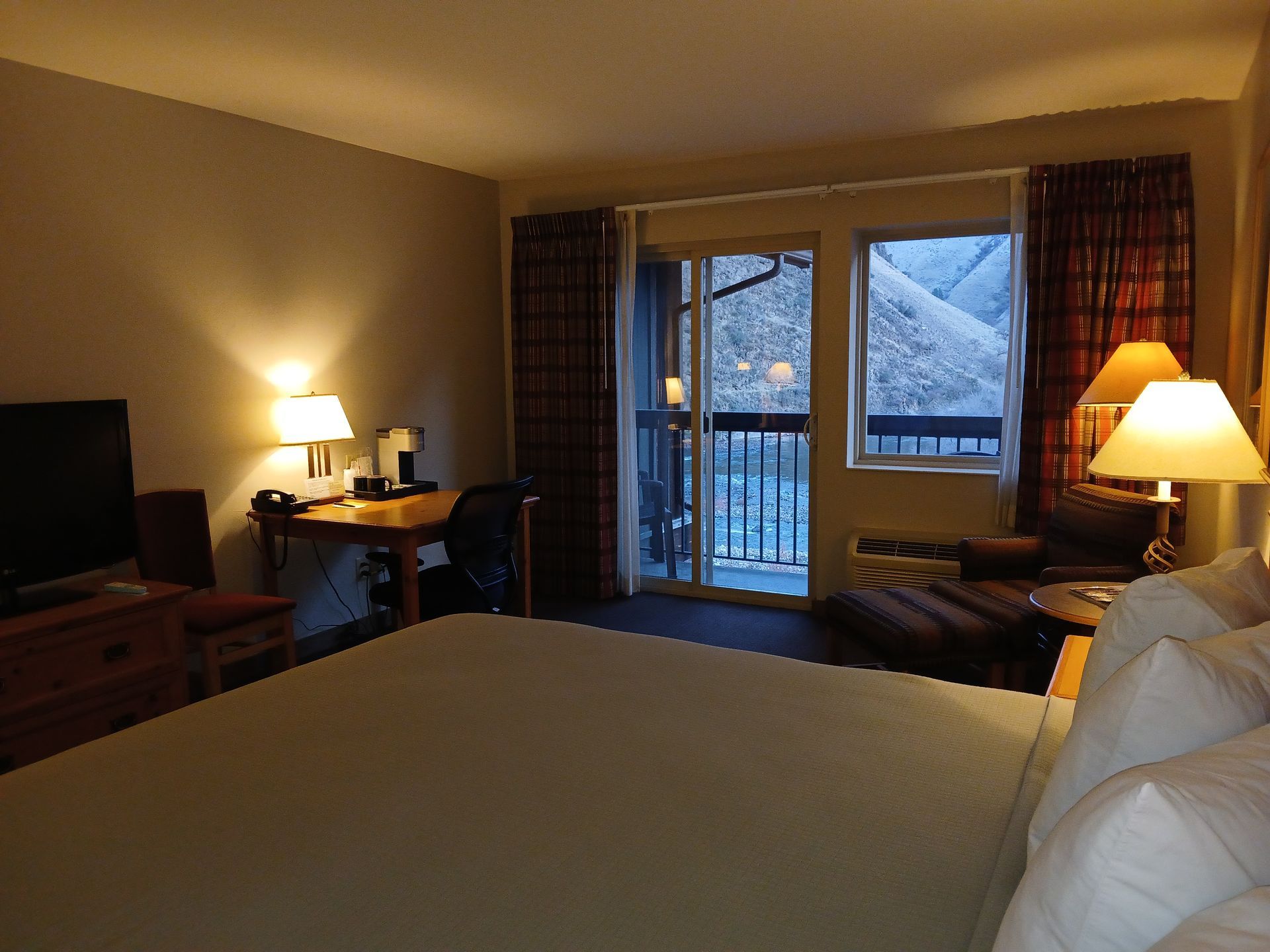 A hotel room with a large bed and a sliding glass door