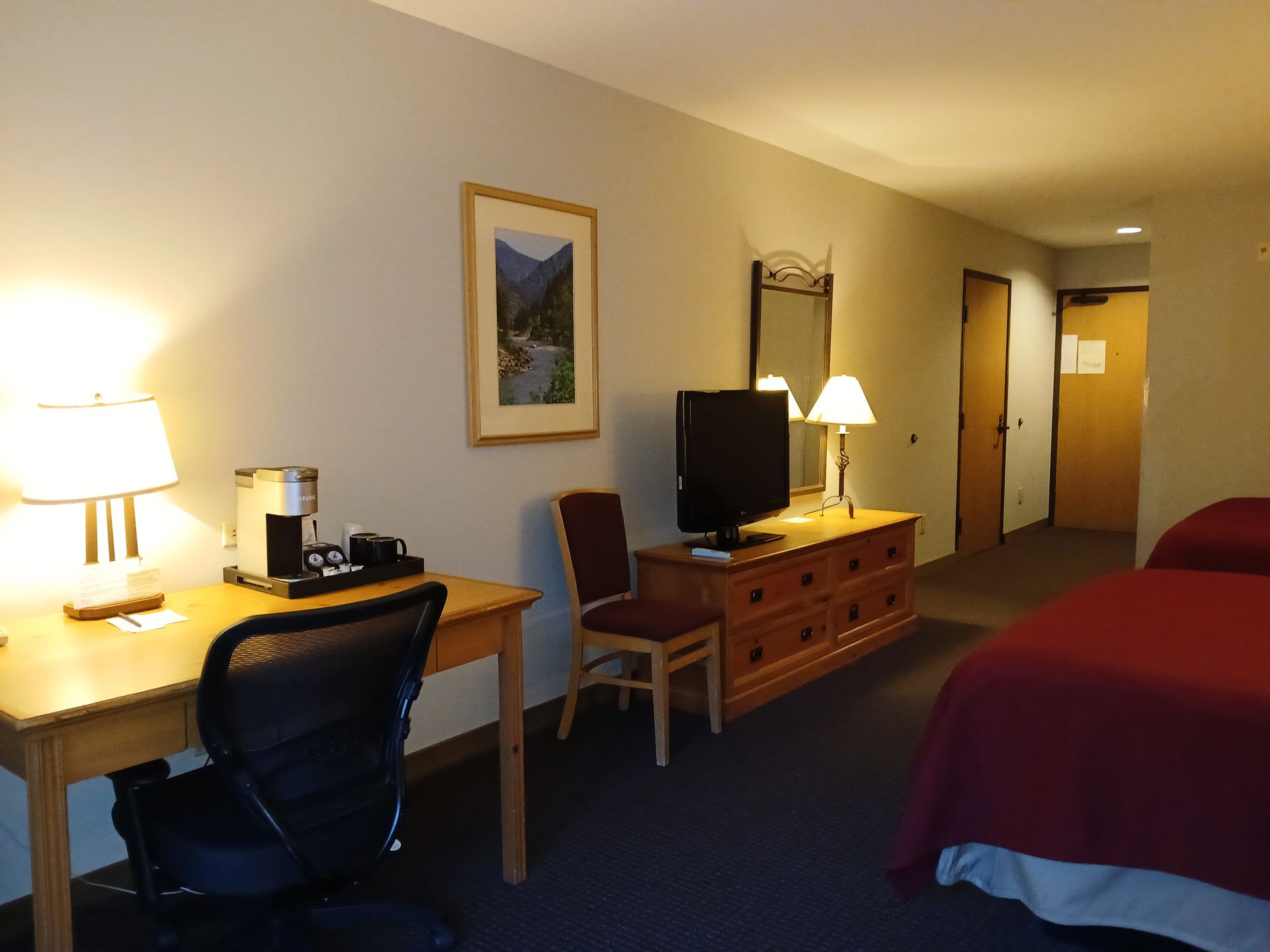 A hotel room with two beds and a desk