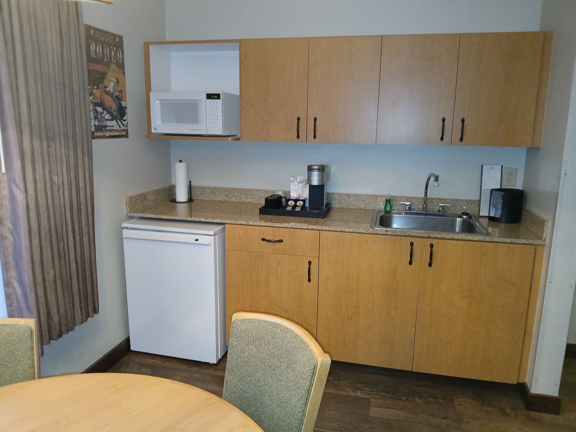 A kitchen with wooden cabinets , a sink , a microwave and a dishwasher.