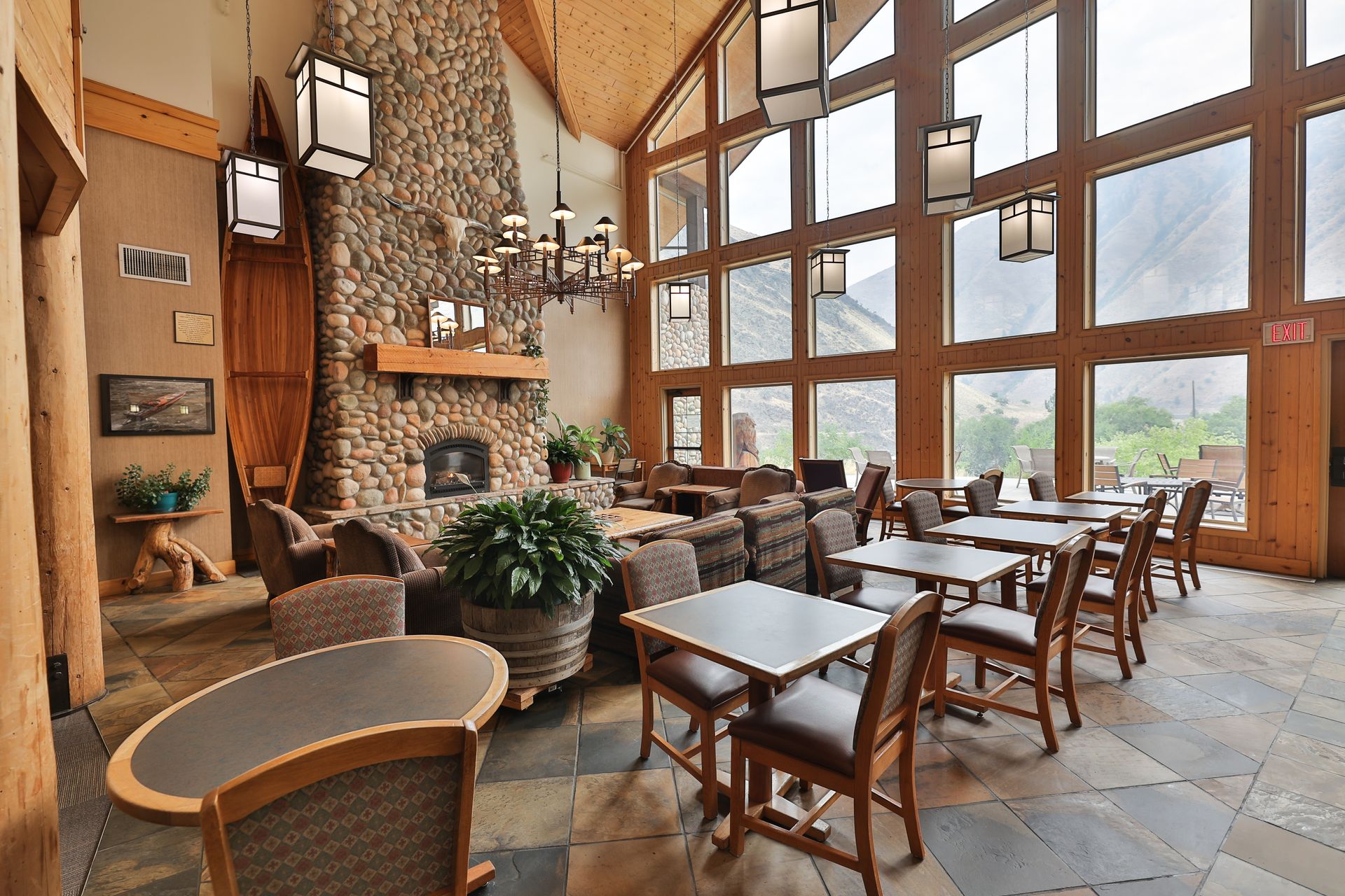 A large room with tables and chairs and a fireplace
