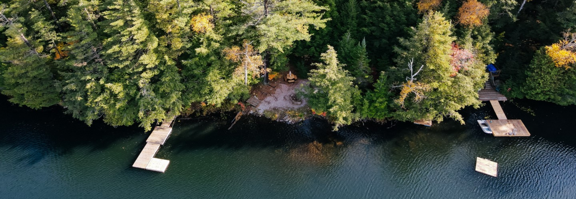 An aerial view of a lake surrounded by trees and a dock.