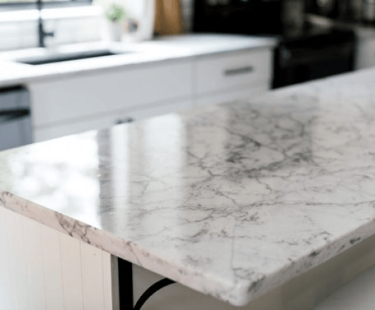 A close up of a marble counter top in a kitchen.