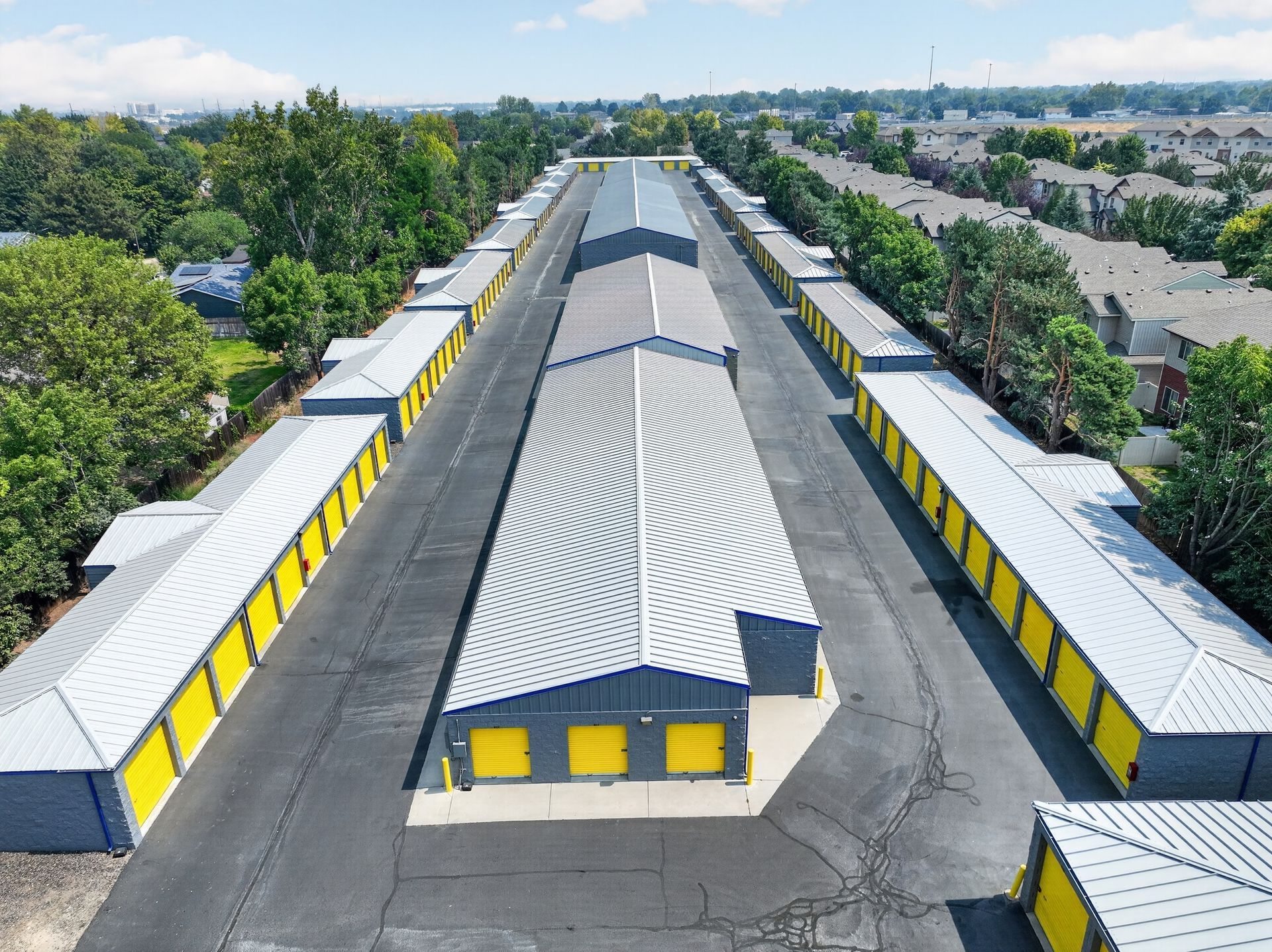Various sizes of outdoor drive-up storage units in Pendleton at Airport Rd with yellow roll-up doors and a wide drive aisle