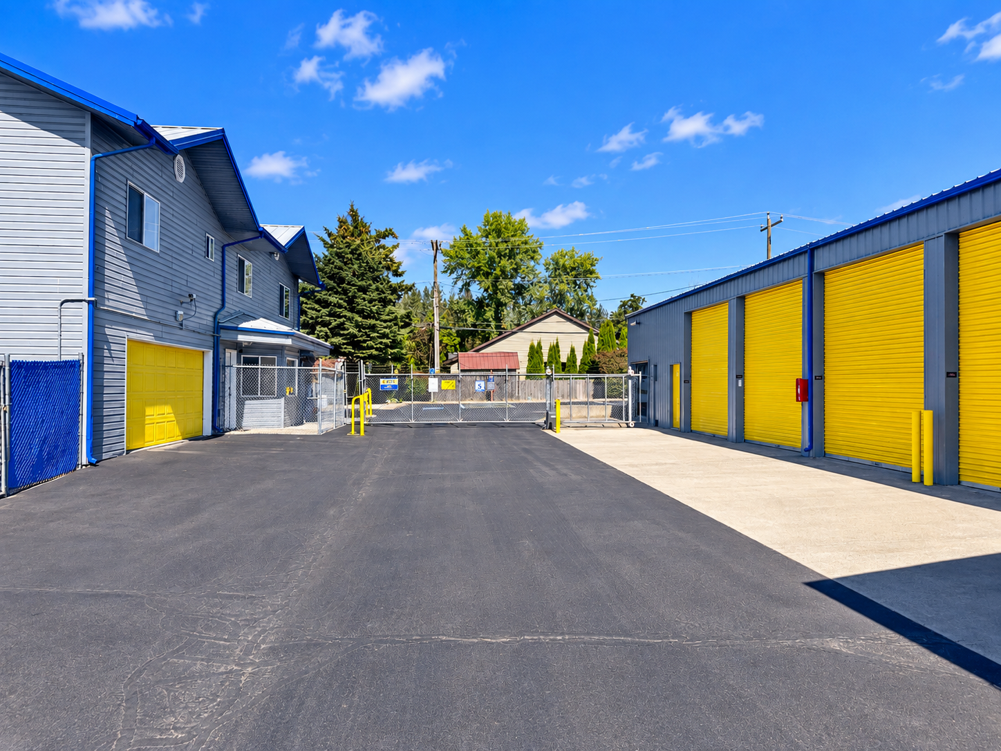 Various sizes of outdoor drive-up storage units in Pendleton at Airport Rd with yellow roll-up doors and a wide drive aisle