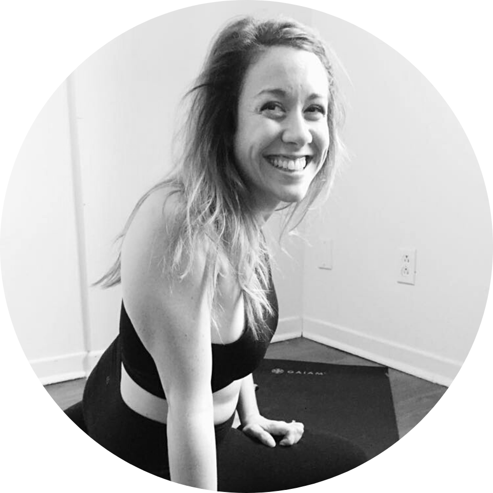 Une femme est assise sur un tapis de yoga et sourit sur une photo en noir et blanc.