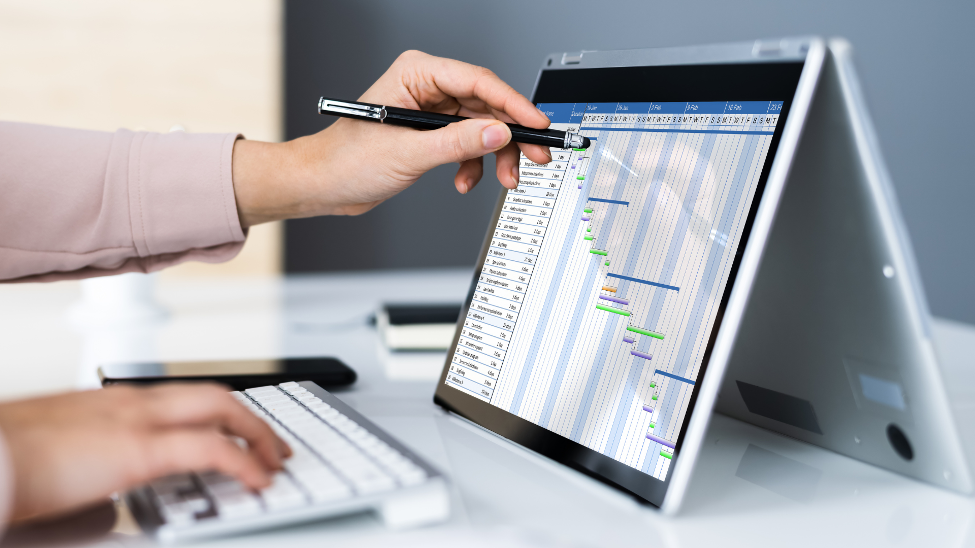 a person is using a laptop computer while holding a pen .