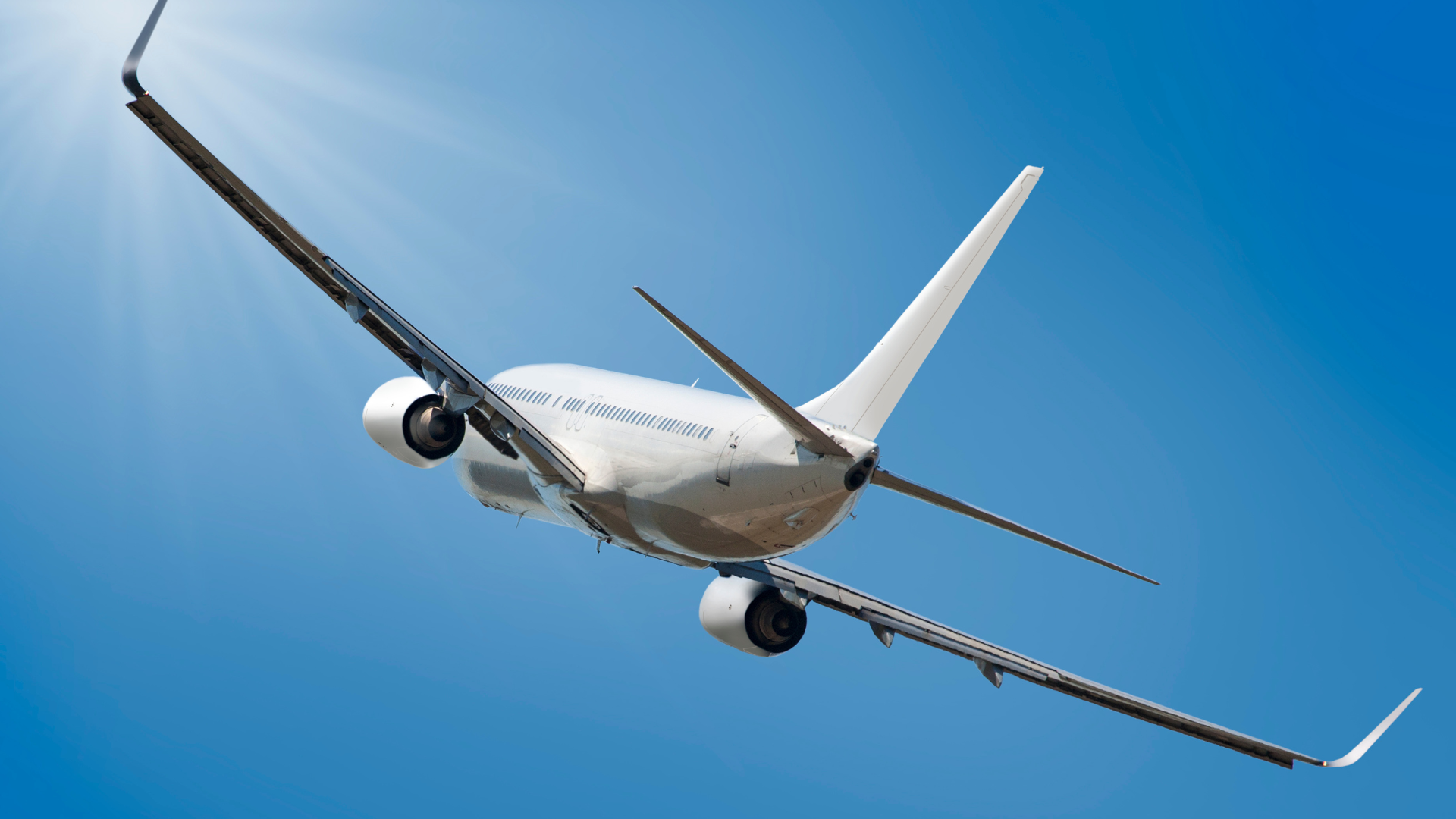 a large passenger jet is flying through a clear blue sky .