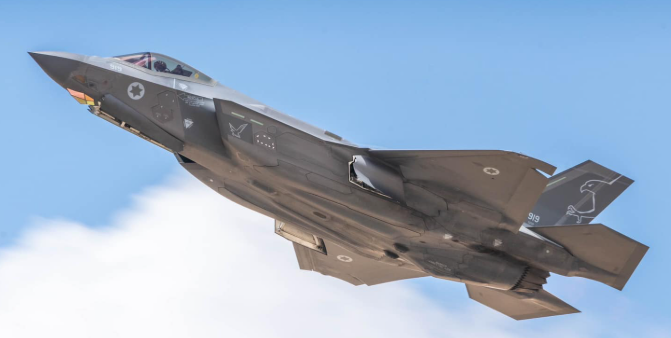 A fighter jet is flying through a blue sky.
