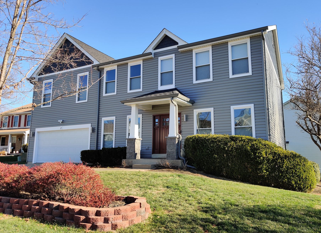 Complete home exterior remodel featuring new siding, cedar shake gables, new windows, gutters, soffit and fascia, and Affinity Stone column wraps in St. Charles County.