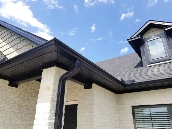 Seamless black gutter installation with gutter guards on a cedar shake home by St. Peters contractor Home Comfort Exteriors.
