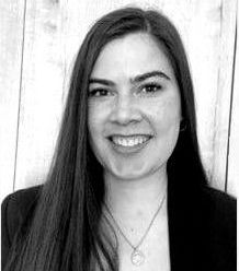 A woman with long hair is smiling in a black and white photo.
