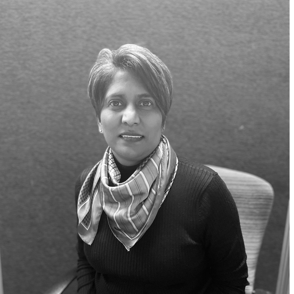 A black and white photo of a woman wearing a scarf around her neck