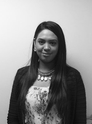 A black and white photo of a woman wearing a necklace and earrings.