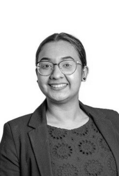 A black and white photo of a woman wearing glasses and a jacket.
