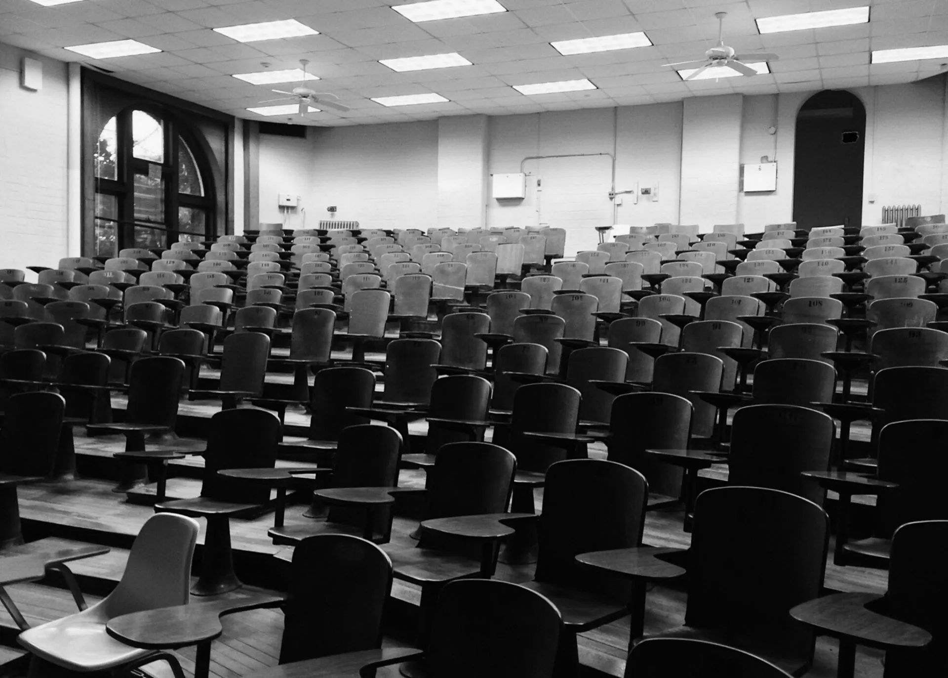An empty auditorium with rows of chairs and tables