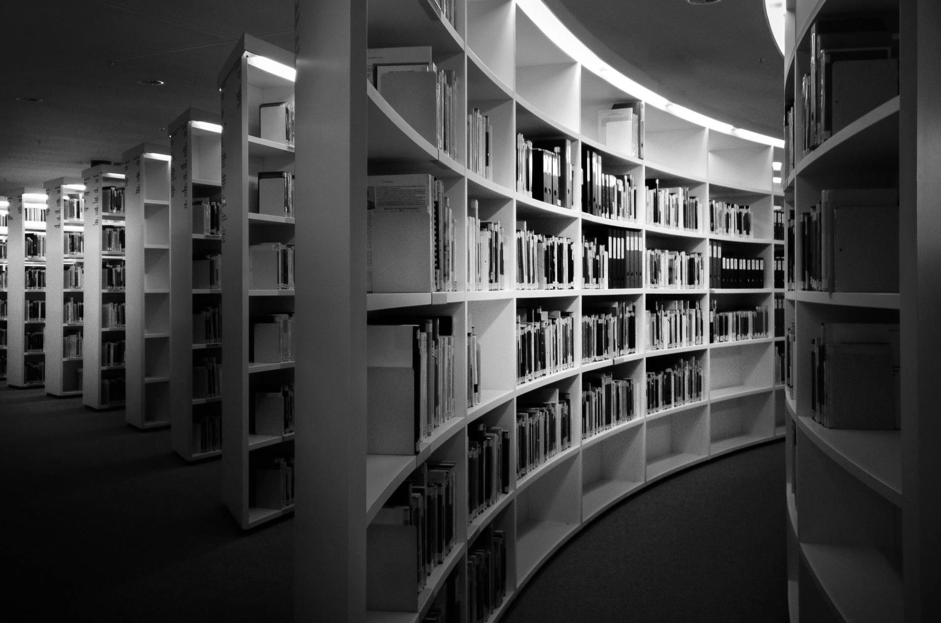 A black and white photo of a library filled with books