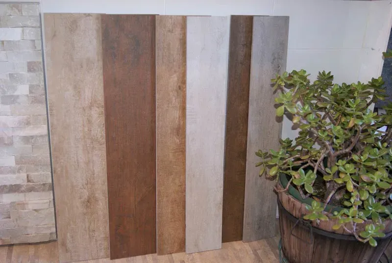 A Potted Plant is Sitting Next to a Row of Wooden Boards — Aussie Carpets & Vinyl In Beerwah, QLD