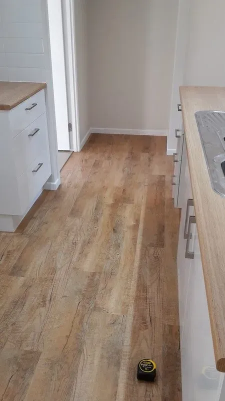 A Kitchen With a Wooden Floor and a Tape Measure on the Floor — Aussie Carpets & Vinyl In Beerwah, QLD
