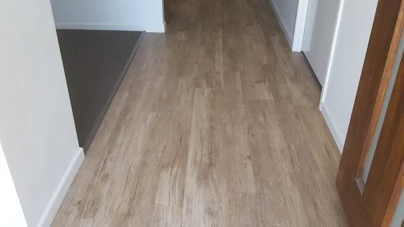 A Hallway With a Wooden Floor and a Door — Aussie Carpets & Vinyl In Beerwah, QLD