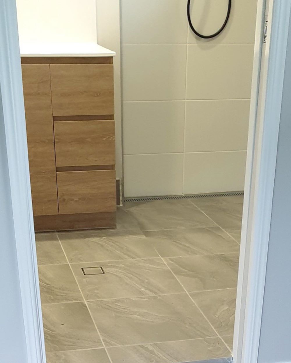 A Bathroom With a Wooden Vanity and a Tiled Floor — Aussie Carpets & Vinyl In Beerwah, QLD