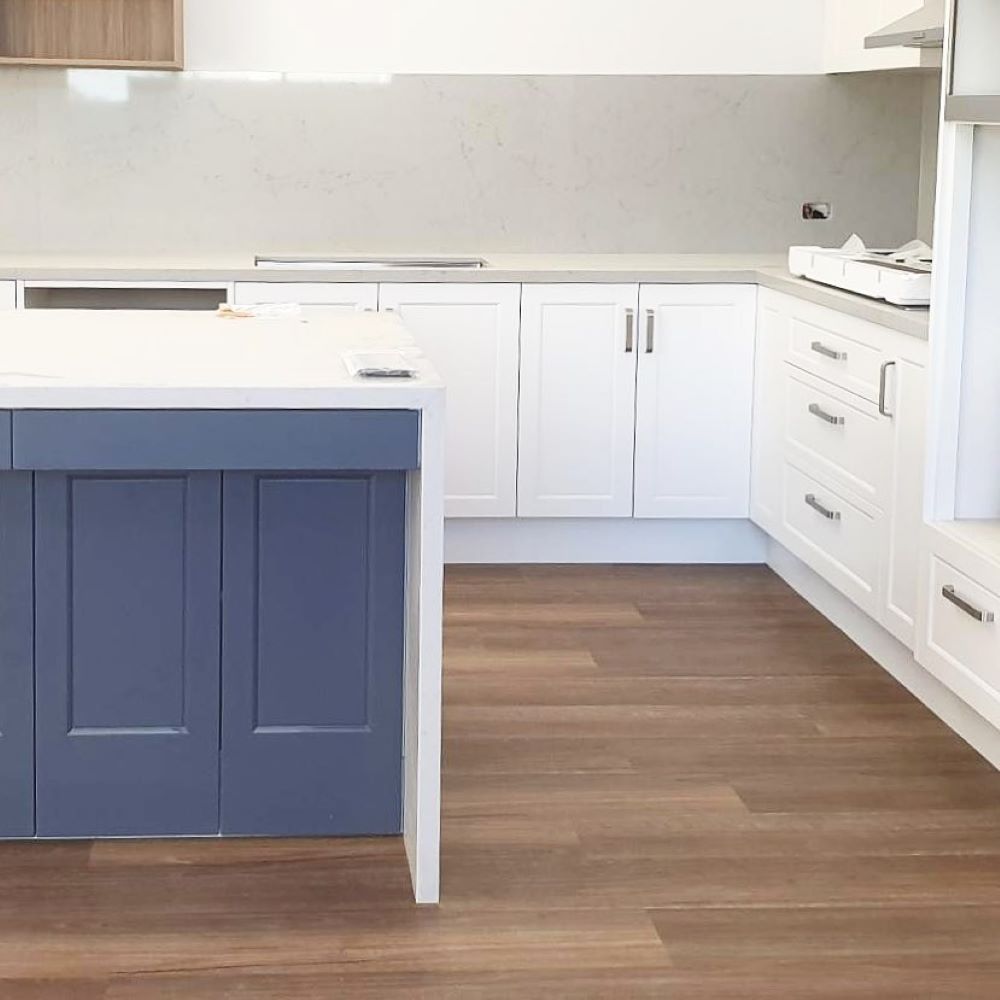 A Kitchen With a Blue Island and White Cabinets — Aussie Carpets & Vinyl In Sunshine Coast, QLD
