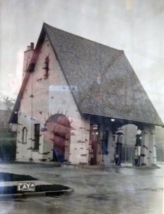Small white church with a steep dark roof on a wet street in rainy weather