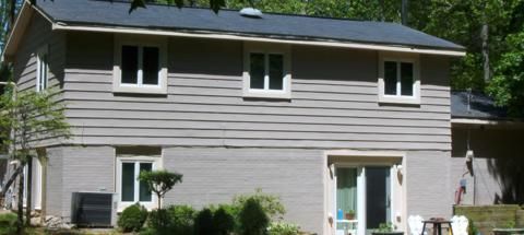 Two-story beige house with white trim after coating