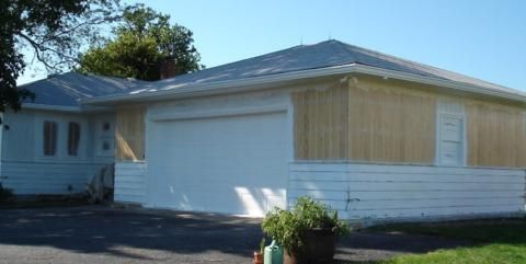 Single-story white house with blue-gray roof and attached garage in a suburban yard