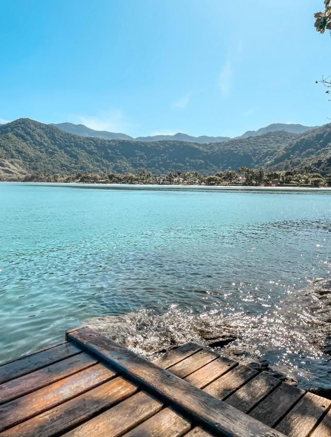 Um cais de madeira com vista para um lago com montanhas ao fundo.