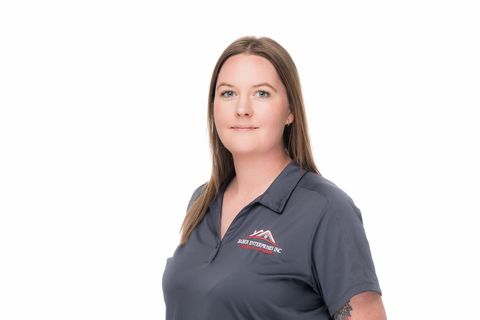 Woman in a gray polo shirt standing against a white background.