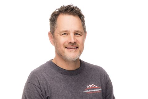 Smiling man in a gray T-shirt against a white background